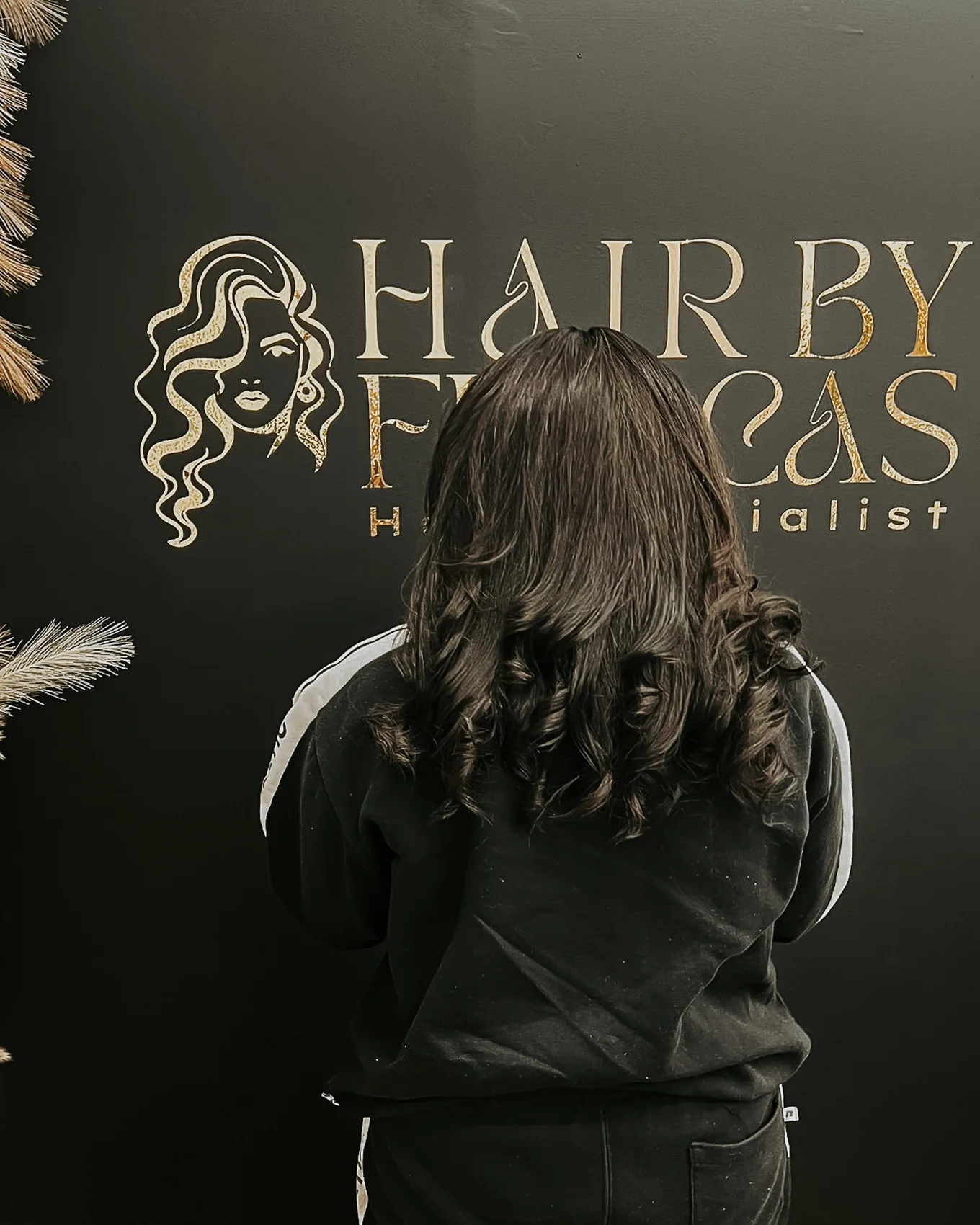 Back view of a smooth hairstyle finished with soft curls